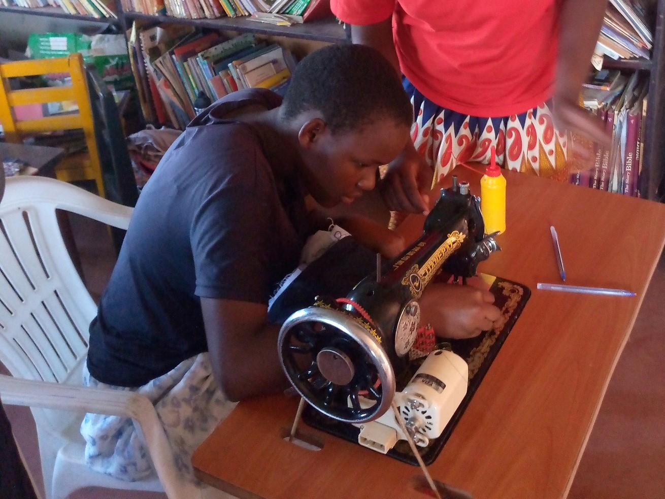 Young Uganda youth works on a sewing project.